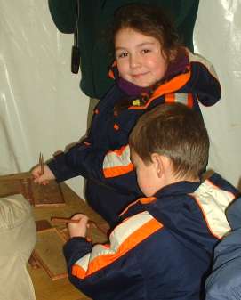 children trying out their skills at Roman tablet writing